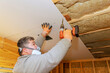 © ungvar - Construction worker secures drywall to ceiling using power drill in cozy indoor area.