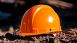 © Benjamin - A orange safety helmet or hardhat for the construction worker which is placed on the ground of construction working site