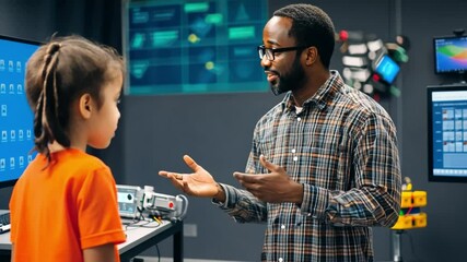 Wall Mural - a man roboticist explains robotics basics, introducing students to the mechanics of building and pro
