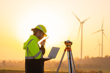 Aufkleber - Engineer working on laptop in front of wind turbines for checking wind turbines of the field during beautiful sunset. Alternative energy concept.
