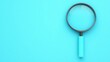 © tonstock - A vibrant turquoise background featuring a classic magnifying glass, ideal for concepts of search or investigation.