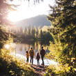 © mindstorm - Family hiking in beautiful forest near lake at sunset