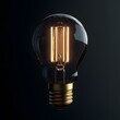 © Muneeb - Light bulb with glowing filament on dark background