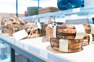 Selection of hand made, thick wooden coasters seen for sale in a well known British department store. Seen within other wooden, craft kitchen utensils.