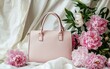 © Marina - Elegant leather handbag in soft blush pink placed next to fresh peonies on a white backdrop