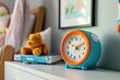 © Thanapong - Brightly colored children's alarm clock on a nightstand cozy bedroom setting playful decor cheerful vibe perfect for kids rooms