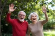 © milkyway - Cheerful Elderly Couple Showing Heart Symbol and Waving Outdoors in Nature