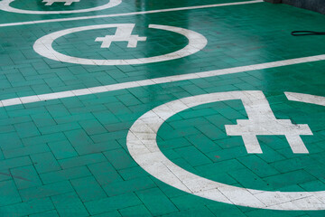 Chargers are marked on the ground, indicating spots for electric vehicles to connect for energy replenishment in a contemporary setting