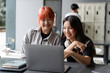 © amnaj - Two happy asian female students using laptop computer, studying and learning together in university library