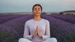 © artchvit - Breathing exercises for natural wellness. Serene woman meditating in a lavender field at sunset.