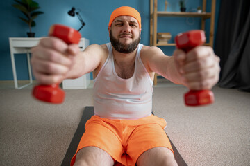 Wall Mural - Determined man lifting dumbbells during home workout