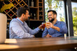 © Mediteraneo - Two male friends hanging out at the restaurant and drinking beer.
