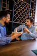 © Mediteraneo - Two male friends hanging out at the restaurant and drinking beer.