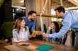 © Mediteraneo - Group of friends toasting in a restaurant with alcohol.