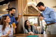 © Mediteraneo - Group of friends toasting in a restaurant with alcohol.