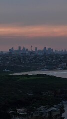 Wall Mural - Drone vertical footage of the Sydney city skyline from Malabar coast at sunset in Australia