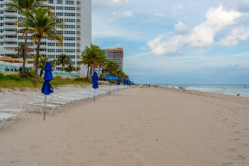 Wall Mural - lounging chairs on beach with city