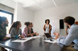 © NDABCREATIVITY - Happy african american female leader holding negotiations meeting with friendly diverse colleague