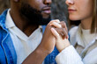 © Koldo_Studio - Interracial couple holding hands, demonstrating affection, trust, and unity in a close up shot