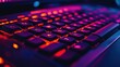 © afif - Illuminated gaming keyboard in a dark room with computer equipment visible in background.  Possible use Stock photo for gaming, technology, or esports