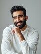 © Viktoriia - Saudi male model smiling with chin resting casually in indoor setting