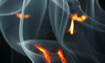 Wall Mural - Glowing embers surrounded by swirling smoke, capturing the essence of a warm fire in a darkened environment