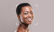 © Prostock-studio - A woman with a bright smile poses in front of a gray background. Facial recognition technology overlays geometric lines and points on her face, illustrating identification capabilities.