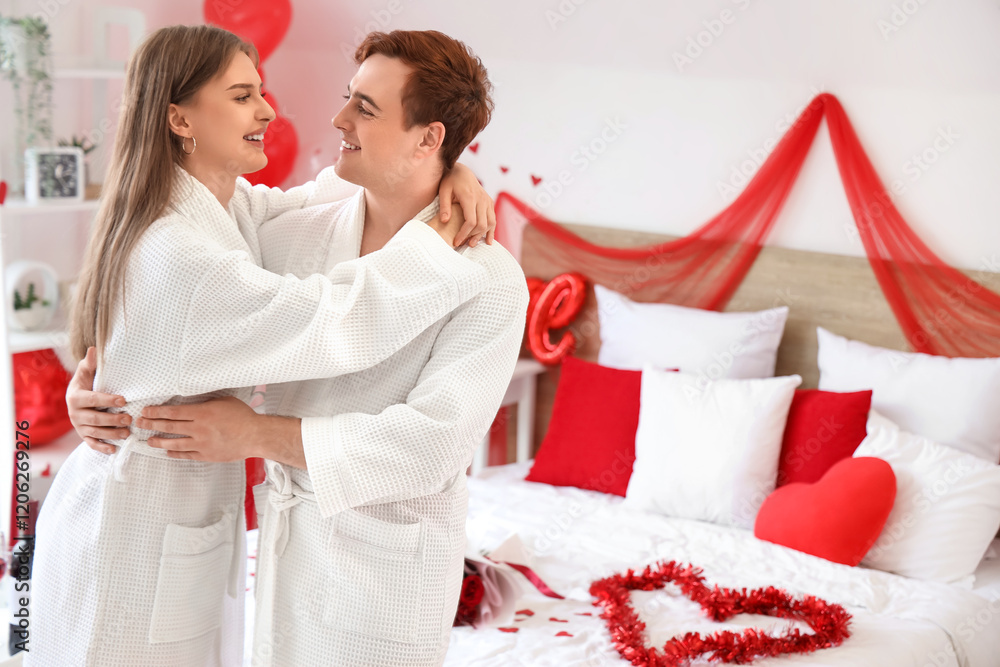 Young couple hugging in bedroom on Valentine's Day