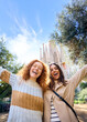 © CarlosBarquero - Vertical portrait memories of young caucasian tourist women friends take photo at Sagrada Familia, Barcelona. Beautiful girls, street of European city looking camera. Vacation happy and smiling.