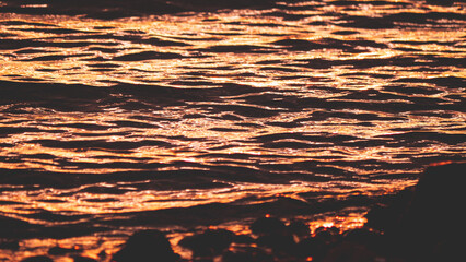 Wall Mural - Colourful vibrant red orange golden sunset into sea ocean water in New Zealand