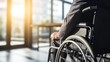 © thesweetsheep - Businessman in a wheelchair, contemplating in a sunlit modern office space.