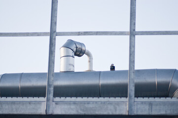 close-up of pipeline and metal fence against grey blue sky