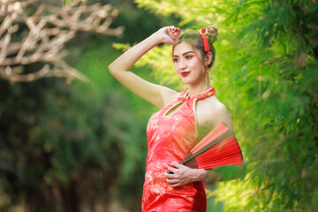 portrait of young asian woman wearing a traditional Chinese red dress is posing.