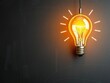 © chaiwat - A stylized lightbulb with a glowing filament drawn on a gray chalkboard background with textured lines and warm colors, artistic, , chalkboard