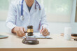 © R Photography - Male doctor working at a desk in a hospital, using a hammer, overseeing legal aspects of healthcare, performing medical duties, managing patient care, ensuring compliance with medical laws,providing