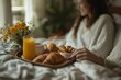 © Gema Vélez - close-up of a breakfast tray brought to bed, juice, croissants and coffee.