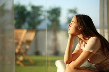 Wall Mural - Woman relaxing closing eyes at sunset at home