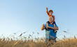 © Westend61 - Grandfather carrying grandson on shoulder in field under blue sky
