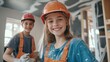 © Elkhan Babayev - Teenage girl painter and young builder boy working on home renovation project, wearing safety gear and smiling happily.