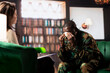 © DC Studio - Distraught soldier in tears sharing his struggles with war PTSD, attends therapy session with expert for rehabilitation. Psychological support and society reintegration for veterans.