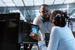 © DC Studio - System administrator working with colleague in data center facility providing computing resources for different workloads. IT expert talking with coworker while monitoring AI supercomputers