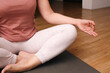 © Trik - Woman practicing breathing exercise. Hand, lotus pose. Woman on a floor for yoga, mediation and zen. Woman Practicing Yoga Indoors.