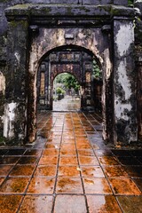 Wall Mural - Weathered stone archway with moss and wet tiles.