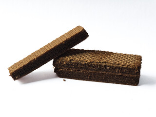 Two chocolate wafer biscuits stacked on a white surface. The crisp texture and rich chocolate layers are clearly visible, creating an appetizing and simple food composition.

