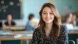 © Ruslan - Portrait of young smiling woman teacher sitting at teacher's desk in school classroom