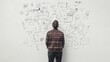 © musa - Man reviewing a complex whiteboard plan.