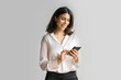 © Stock 4 You - Smiling young middle eastern Israel businesswoman using smartphone mobile phone online app for work isolated on white background. Indian or arabic woman in business suit holding cellphone. Copy space