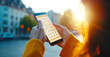 © colnihko - Young hispanic female checking calendar on smartphone outdoors at sunset
