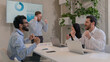 © Yuliia - Happy team colleagues celebrate winning business deal achieve victory give high five multiethnic businessmen and muslim businesswoman in hijab working in boardroom office unity partnership teamwork
