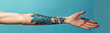 © kora studio - detailed tattoo of blue rose on person arm against blue background, showcasing intricate designs and floral elements